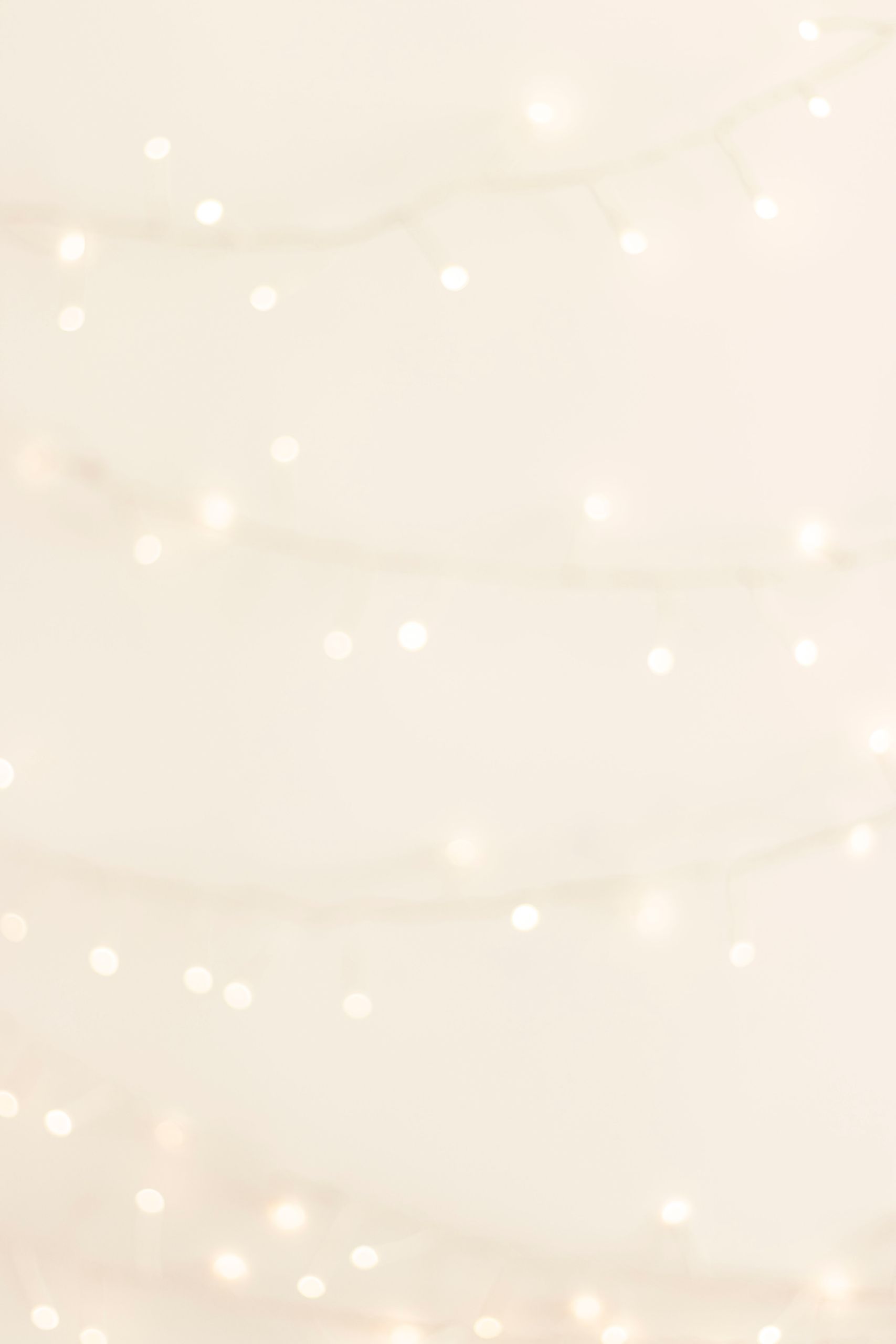Ethereal white bokeh lights on a soft cream background, perfect for festive and elegant designs.