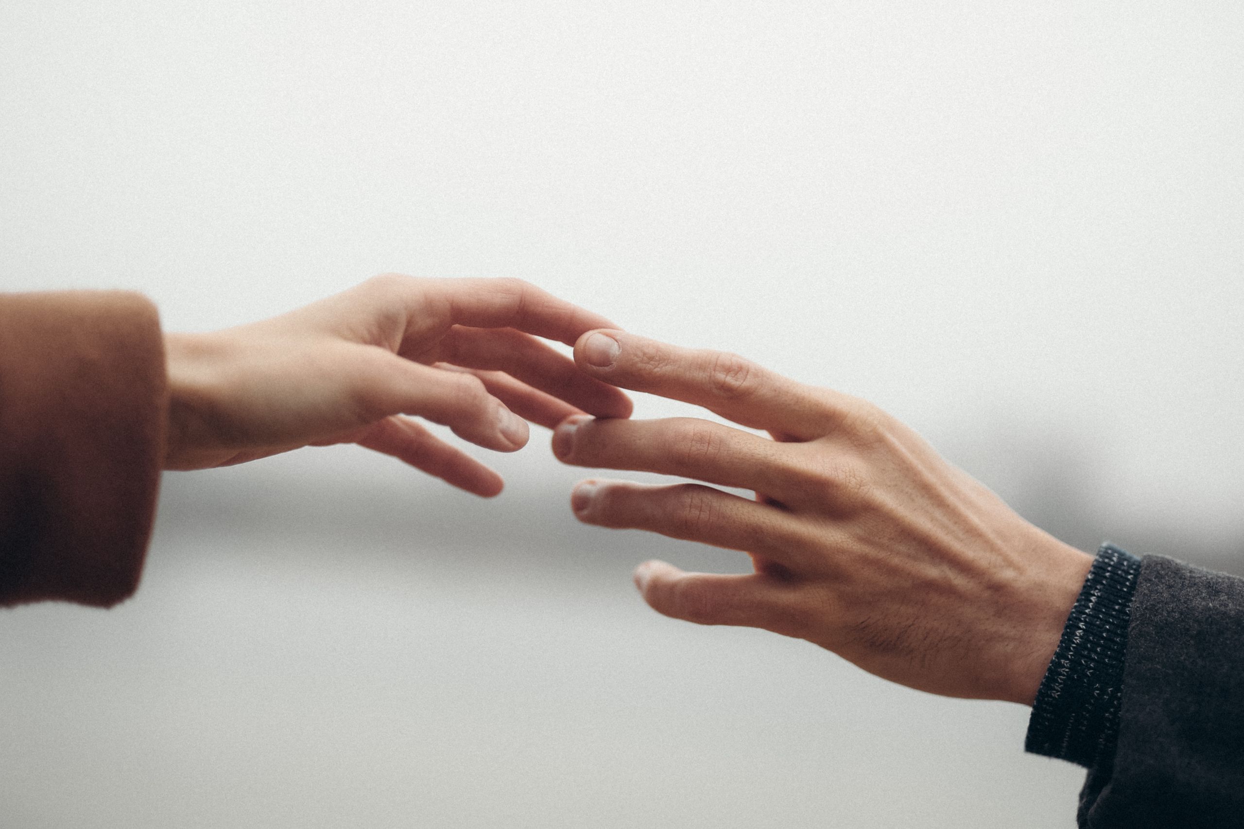 Two hands reaching out, symbolizing connection and intimacy.